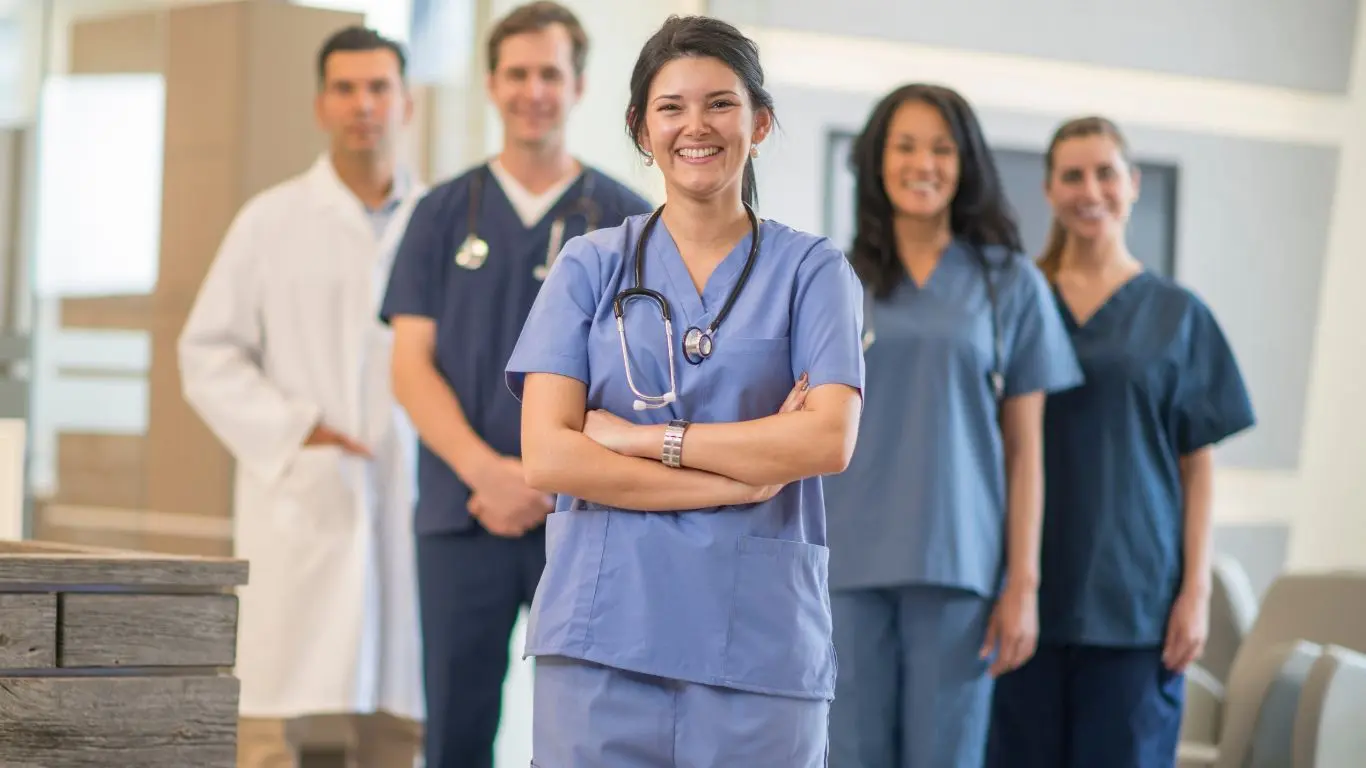 A line of nurses looking into the camera, smiling.